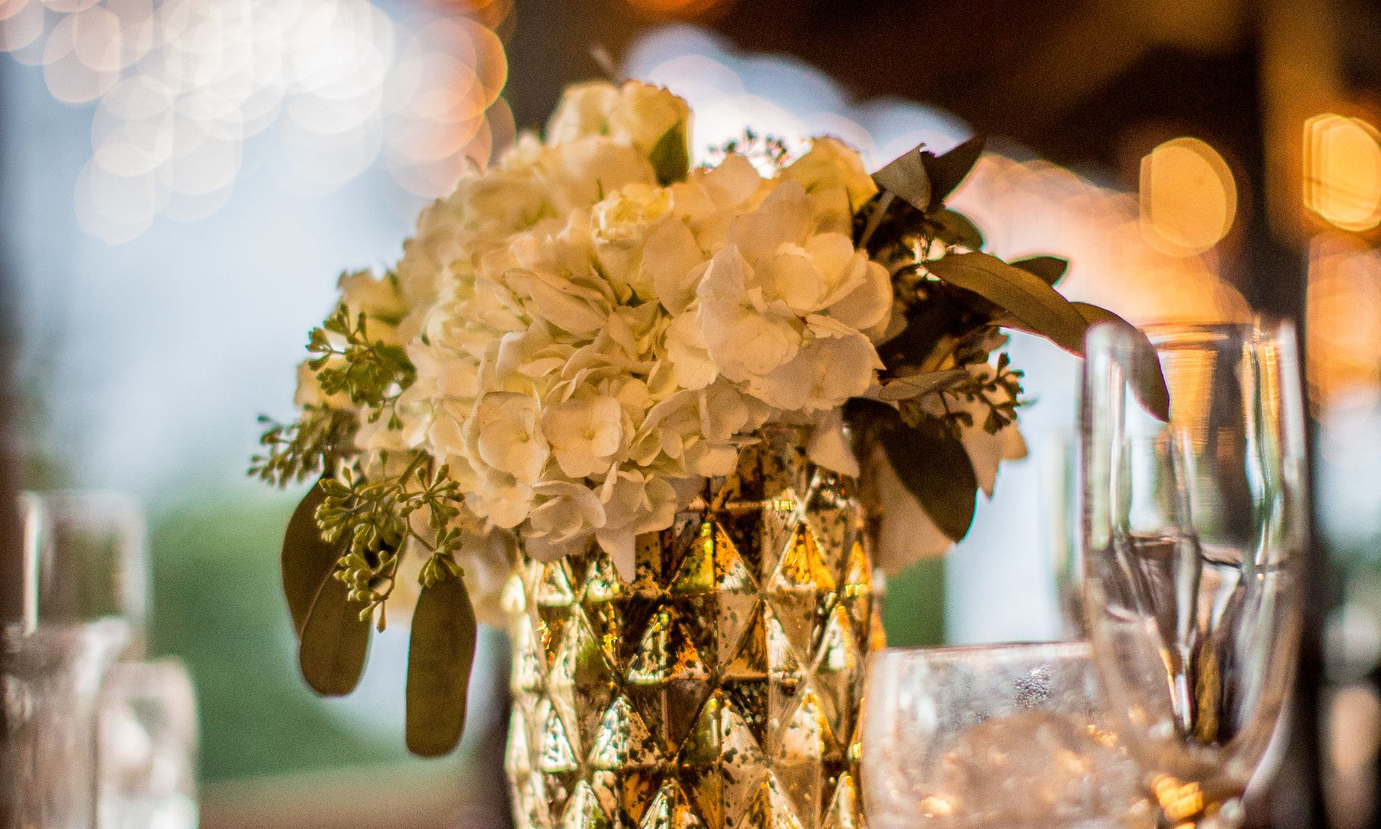 Vase doré aux hortensias dans une lumière chaude du soir